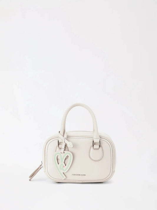Light toast-shaped white crossbody bag on a sunny table