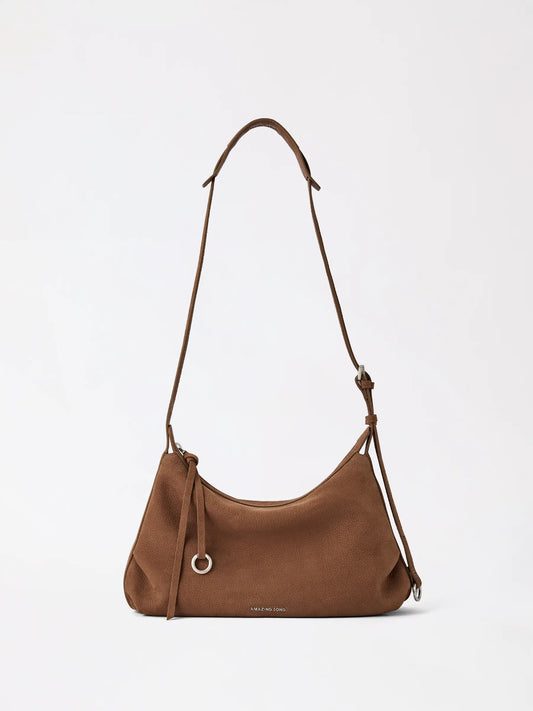 Small donut-shaped top-grain cowhide hobo bag in warm tan leather resting on a neutral surface