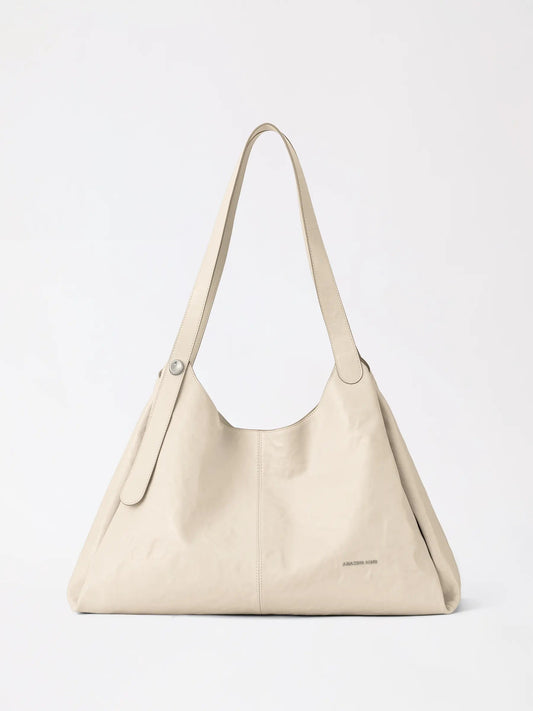 Berry Tote Bag in top-grain cowhide leather resting on a sunny table