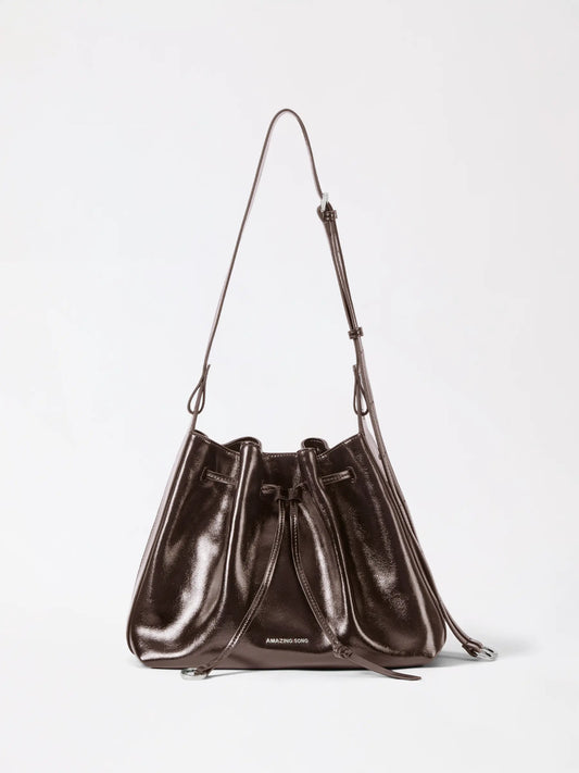 A cute donut drawstring bucket bag in tan leather with a smiling face