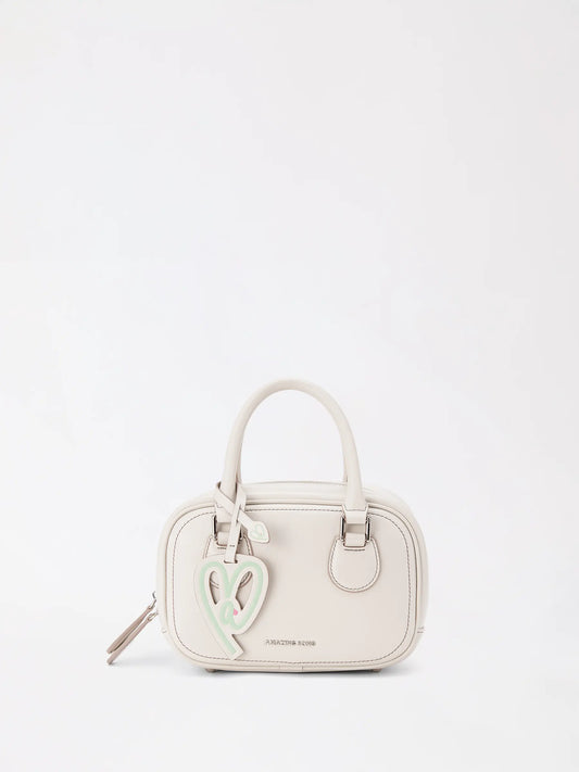 Small toast-shaped top-grain leather bag held in one hand against a neutral background