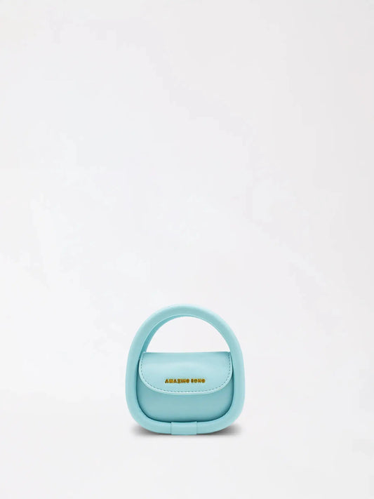 A round bakery-inspired mini leather bag in soft tan on a neutral surface