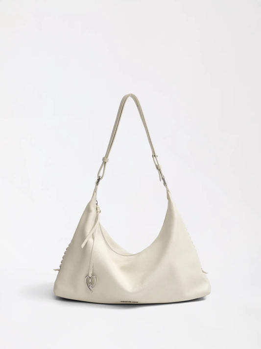 A hand-woven leather hobo bag in warm tan resting on a linen surface