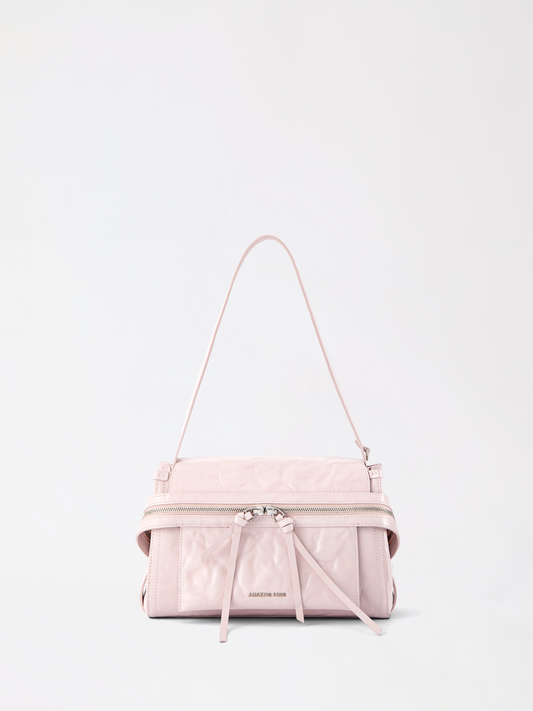 Structured small cheese roll briefcase in top-grain leather standing upright on a desk