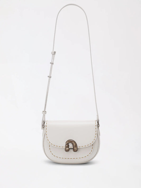 Warm chestnut top-grain leather bag resting against a cream knit sweater