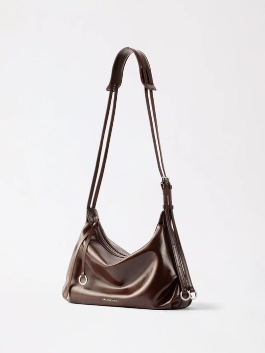 A woman holding the AMAZING SONG donut hobo bag in genuine leather, a bakery-inspired handbag with a soft circular silhouette