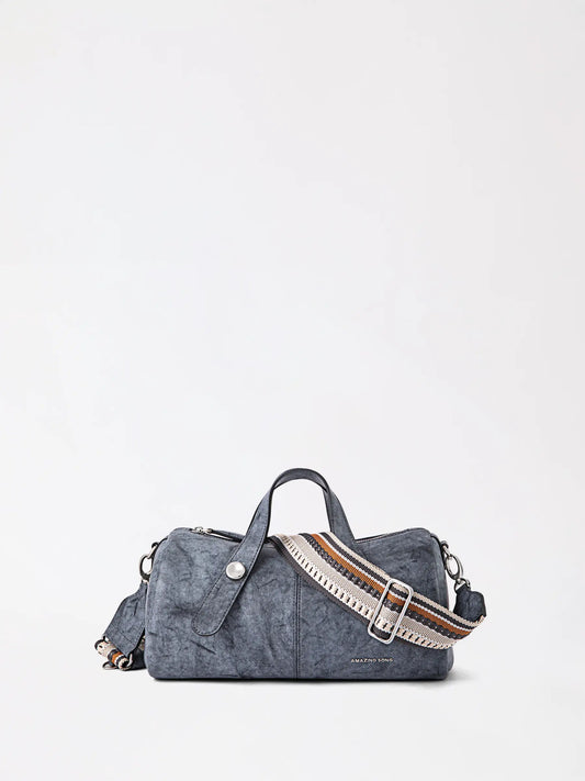 Top-grain leather berry-shaped handbag in a soft pink tone resting on a neutral surface