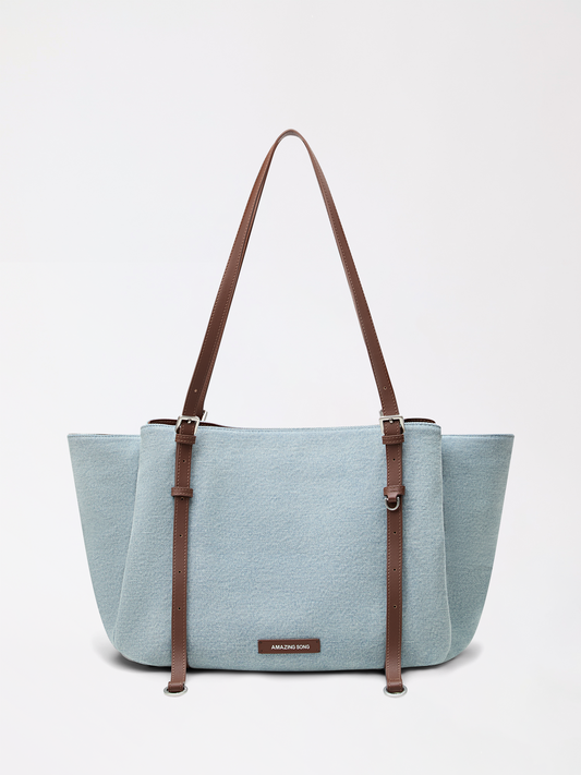 A denim and canvas tote with playful donut inspiration in soft blue
