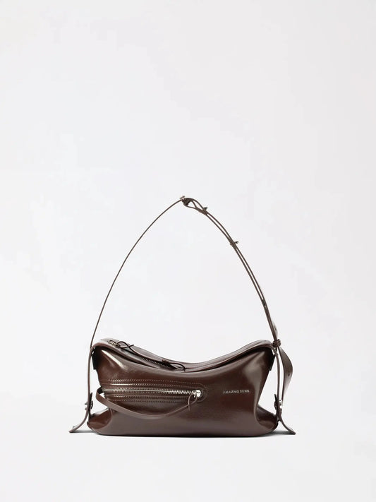 A waxy small evening bag in malt yellow leather against a dark backdrop