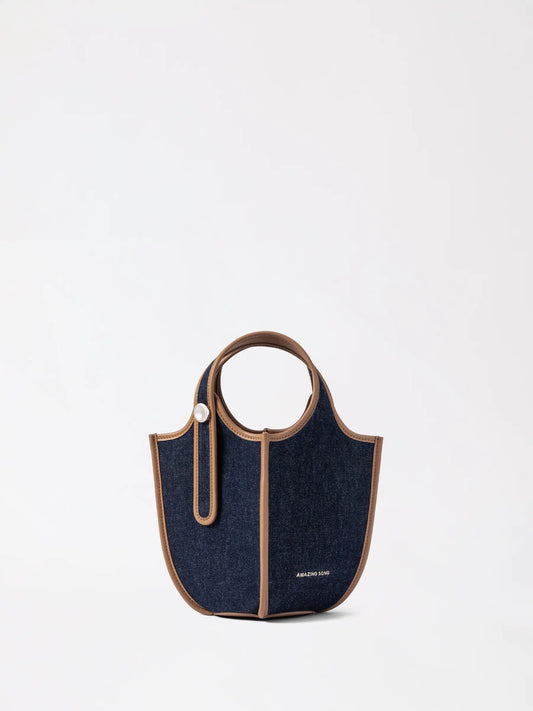 AMAZING SONG hanging basket leather bag in a warm caramel tone photographed hanging on a peg