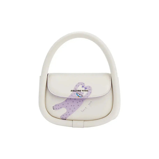 A soft top-grain leather bag with polished gold-tone hardware resting on a linen surface