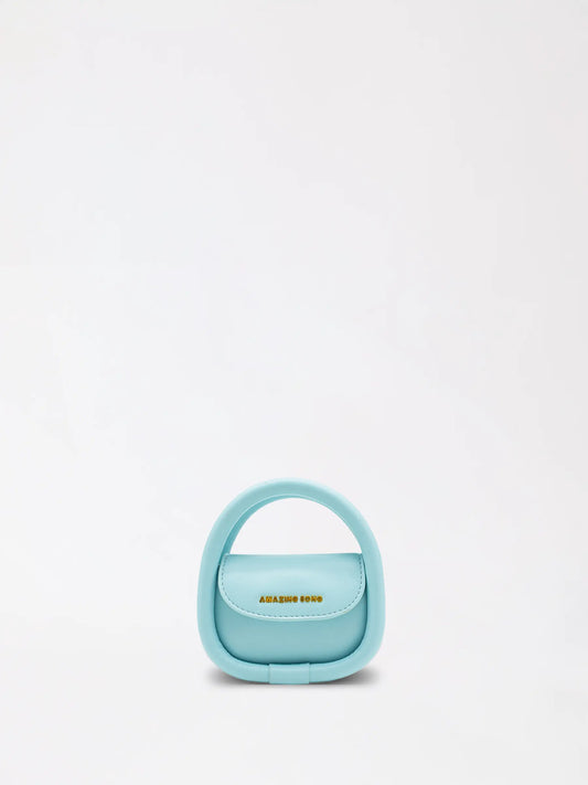A small cute leather mini bag in warm tan resting on a neutral knit