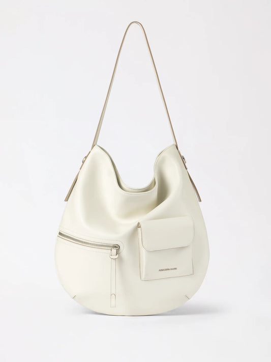 A slouchy liqueur hobo bag in soft leather resting against a knit sweater